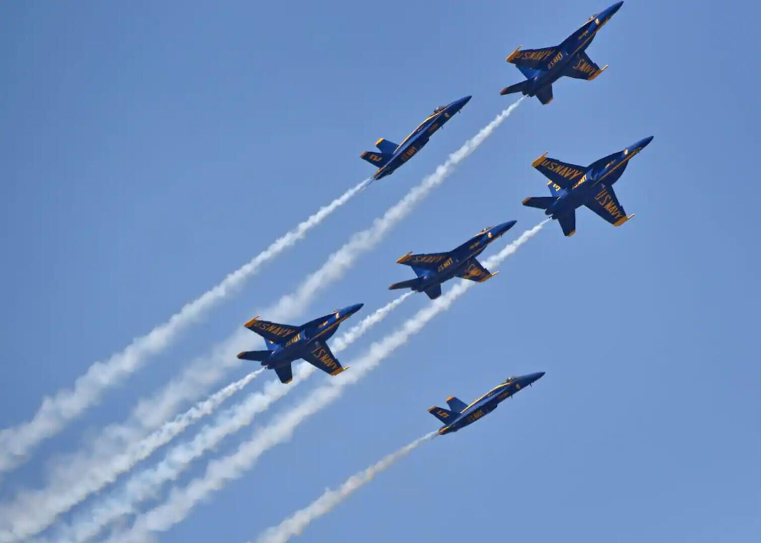 En gruppe jetflyv i formation med spor af røg.