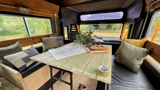 Een gezellig interieur met een tafel, kaart, plant en zithoek.