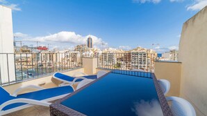 A rooftop pool with lounge chairs, a view of the cityscape, and a clear sky. - Amazing Views of Spinola Bay in Heart of St.julians (St. Julian's)