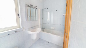 A bathroom with a sink, mirror, and bathtub. - Amazing Views of Spinola Bay in Heart of St.julians (St. Julian's)