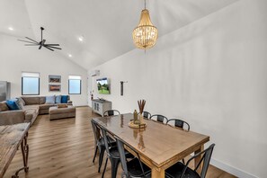A spacious living area with a wooden dining table, a sofa set, and a chandelier. - Desert Bungalow #h8 3 Bedroom Home (Hurricane)