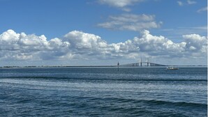 A coastal view with a bridge and a boat in the distance. - Kickback Cabana managed by Beach Retreats (Holmes Beach)