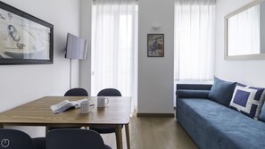 Relax in this stylish living space with a dining table, sofa, and flat-screen TV.