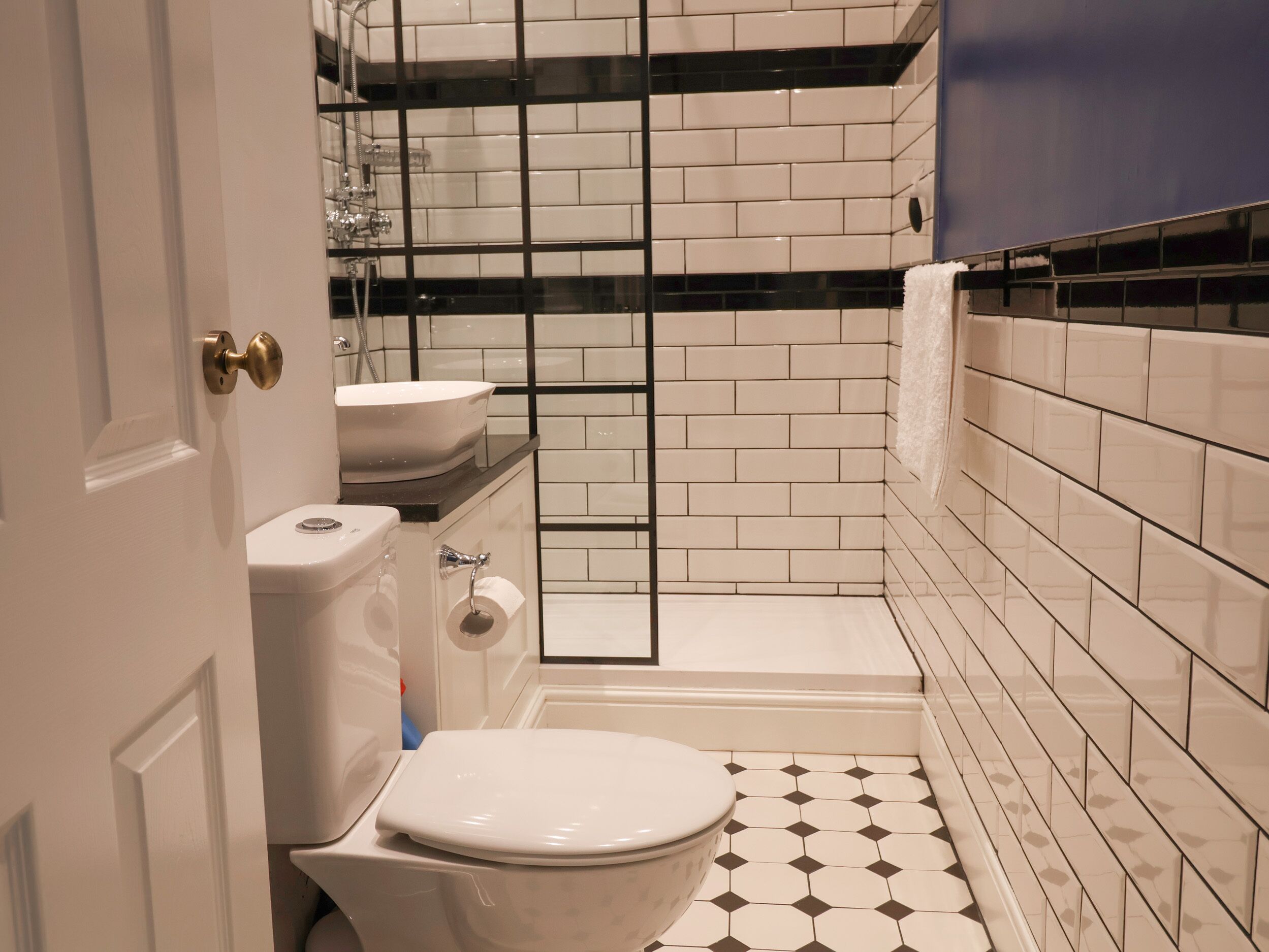 Een badkamer met toilet, wastafel en douchehoek.