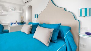 A modern bedroom with a large bed, a bedside table, and a wall-mounted lamp. - Medusa Suite in Positano (Positano)