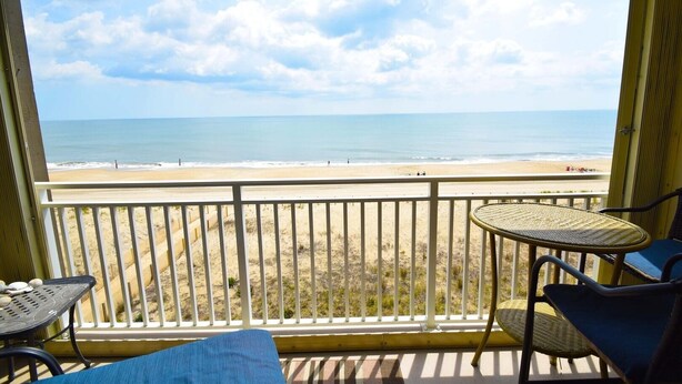 Een balkon met uitzicht op het strand en de oceaan.