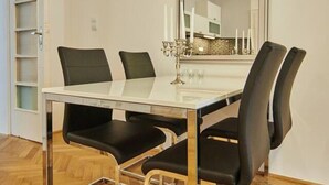 A dining area with a glass-top table, black chairs, and a decorative candle holder.