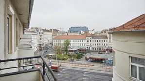 A view of a city street with buildings, a roundabout, and a large blue building in the distance.