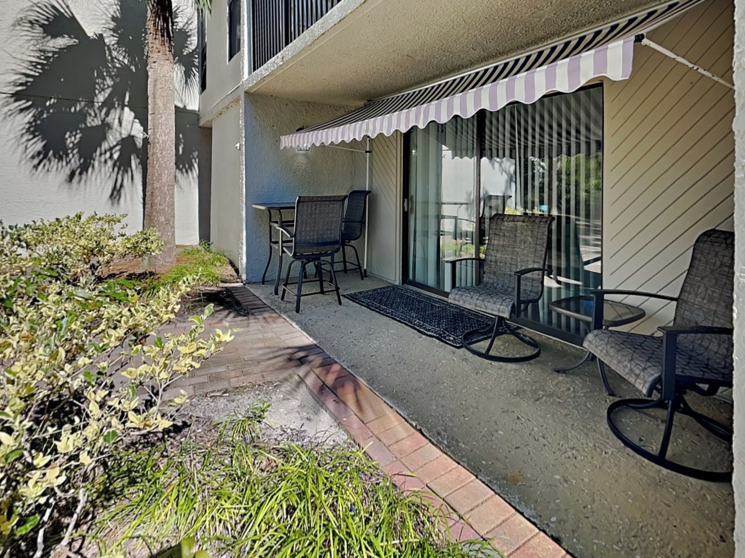 A balcony with outdoor seating, a small table, and a chair.