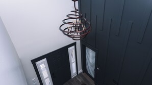A staircase with dark wood railings and a spiral light fixture above. - Sunset Views! Indoor Sport Court, Pool table, Golf Course, 12 min to downtown  (North Salt Lake)