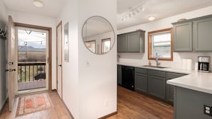 A kitchen with grey cabinets, a white countertop, and a built-in dishwasher. - Cozy Modern Cabin Surrounded by Nature & Pet Friendly! (Grand Lake)