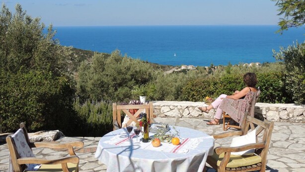 Eine Terrasse mit Tisch für zwei Personen, mit Blick auf die Küste.