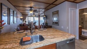 A kitchen with granite countertops, a dishwasher, and a ceiling fan.