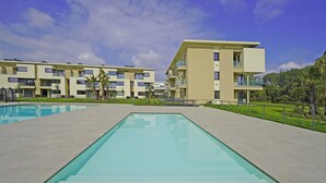 A modern hotel with a swimming pool, multiple balconies, and a well-maintained lawn. - Katya Resort A3 9 by Wonderful Italy (Desenzano del Garda)
