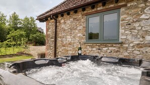 Un edificio de piedra con un jacuzzi en la parte delantera.