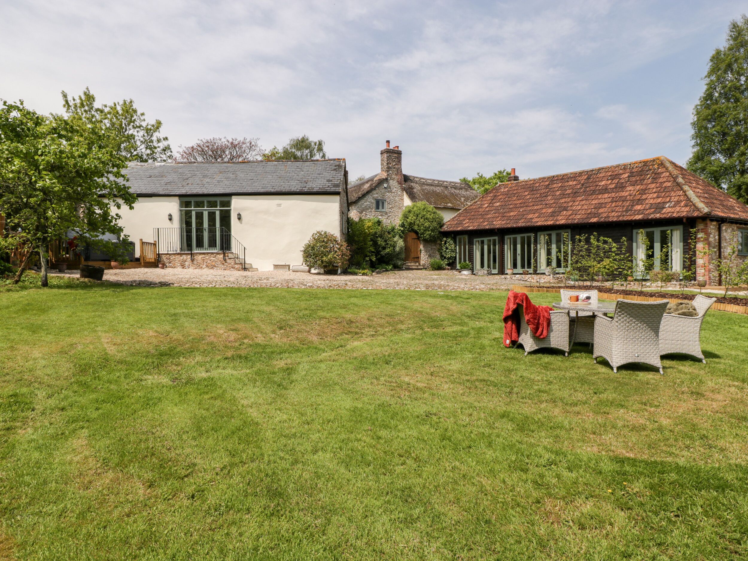 A spacious outdoor area with a lawn and a dining table set up.