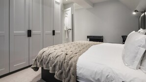 A bedroom with a bed, a nightstand, a dresser, and a wardrobe. - The Park Lane Penthouse (London)