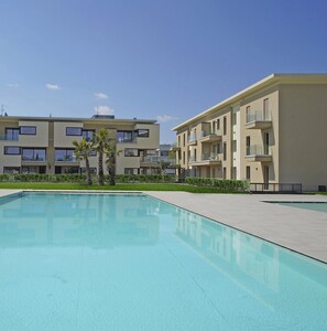 A modern apartment building with a swimming pool in front. - Katya Resort A3 10 by Wonderful Italy (Desenzano del Garda)