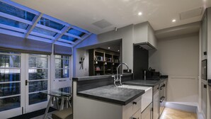 A modern kitchen with a large island, a skylight, and a herringbone wood floor. - The Hanover Suite in London (London)