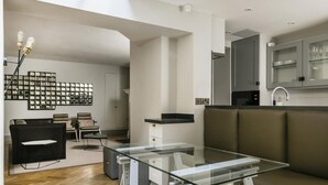 A modern interior with a glass table, a sofa, and a kitchen area. - The Hanover Suite in London (London)