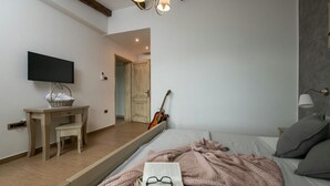 A bedroom with a bed, a television, a guitar, a desk, and a chair. - Villa Casa Brazzana Zadarvillas (Buzet)