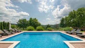 A swimming pool with lounge chairs and a view of trees and hills. - Villa Casa Brazzana Zadarvillas (Buzet)
