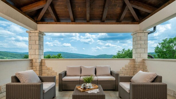 A covered outdoor seating area with wicker furniture and a stone pillar structure. - Villa Casa Brazzana Zadarvillas (Buzet)