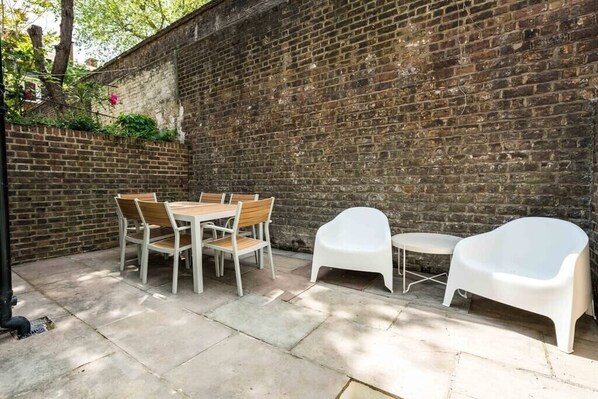 Enjoy al fresco dining at this outdoor patio with a round table and comfortable seating for six.
