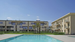 Ein modernes Apartmenthaus mit Schwimmbad und gepflegter Bepflanzung.