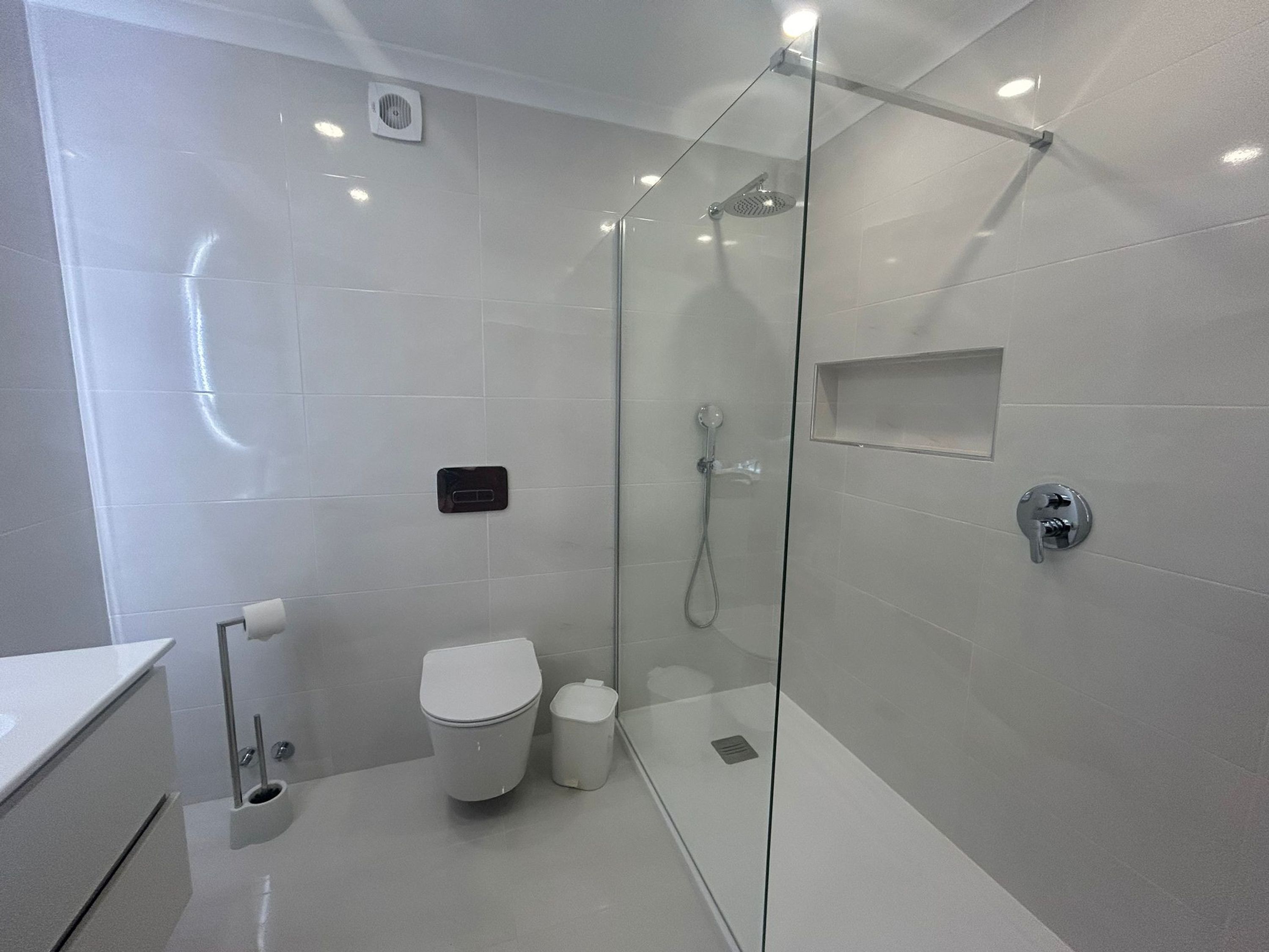 Ein modernes Badezimmer mit einer Duschkabine, einer Toilette und einem Bidet.