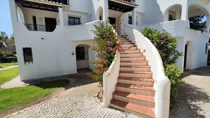 Un bâtiment blanc avec un escalier en colimaçon menant à un balcon.