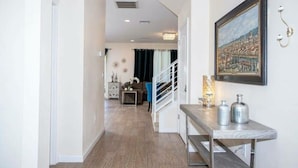 A hallway with a marble bench, a framed painting, and a staircase leading to another room. - Amazing House Verandapalms 6Bd With Pool (Kissimmee)