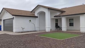 A single-story house with a garage, a covered porch, and a small lawn area.