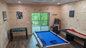 A pool table in a wooden room with a dartboard, a foosball table, and a pinball machine. - Ultimate Entertainment Cabin w/ Theater & Game Room! (Martin)