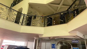 A multi-level interior with ornate black railings and a glass elevator entrance. - Hotel Bosque Chapinero (Bogotá)