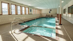 Una piscina interior con agua cristalina, paredes y suelo de baldosas.