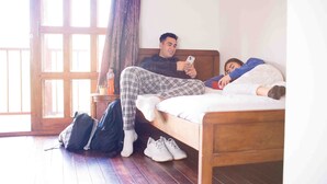 A room with a wooden bed, a window with a view, and a suitcase on the floor. - Cabin 1 - Dakeva (El Peñol)