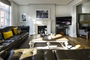 A living room with a fireplace, a sofa, a coffee table, and a television.
