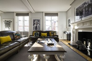 A living room with a sofa, coffee table, and fireplace.