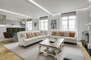 Relax in this stylish living space with a dining area, sofa, and kitchen.