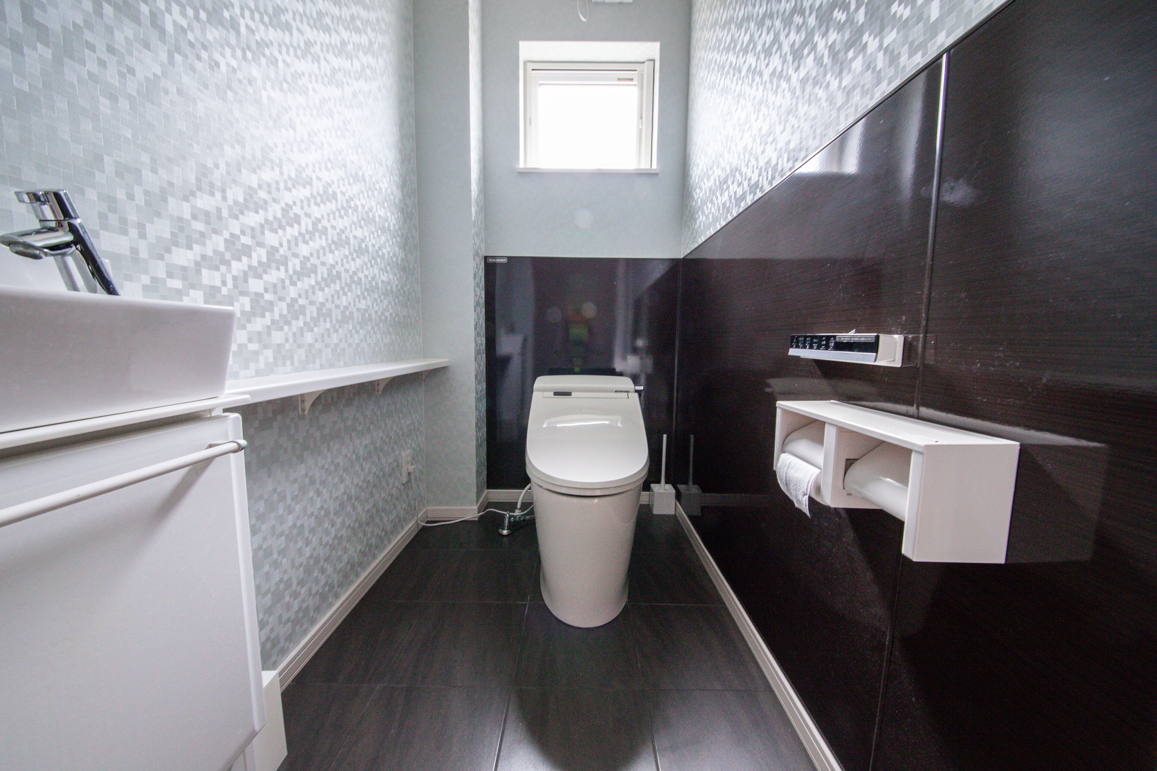 A bathroom with a toilet, a sink, and a mirror.