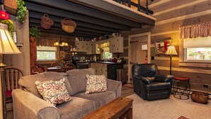 Ein gemütliches Wohnzimmer mit einer Couch, einem Ledersessel und einer Holzbank.
