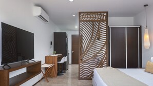 A modern bedroom with a bed, TV, and a desk area. - Menesse PH (Tulum)