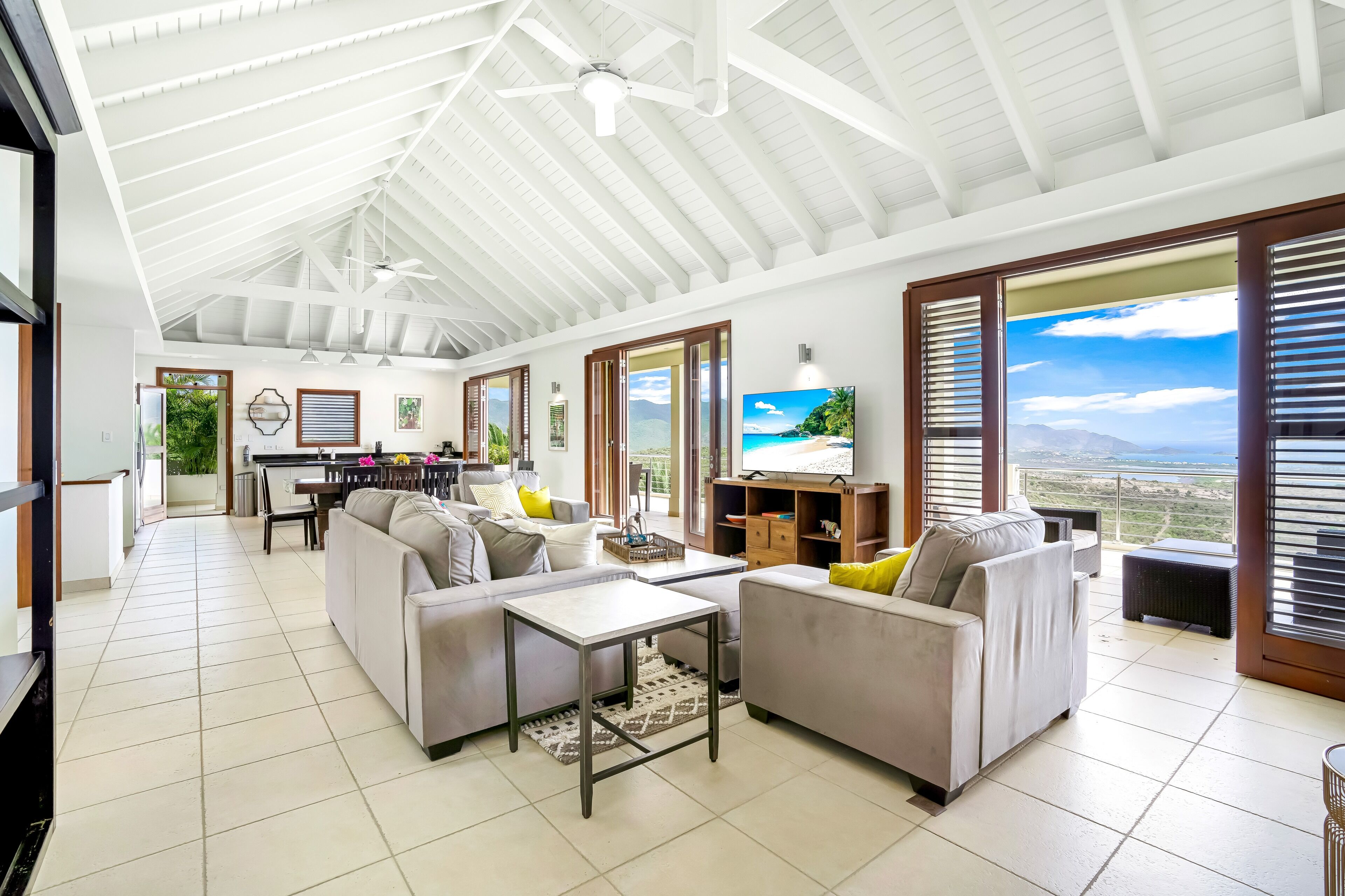 Un salón amplio con techo alto, ventanas grandes y vistas al paisaje.