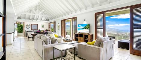 Un salón amplio con techo alto, ventanas grandes y vistas al paisaje.