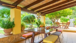 An outdoor patio with a wooden table, benches, and potted plants. - MARINA (POLLENÇA)  - Charming country house with private swimming pool and free WiFi (Pollença)