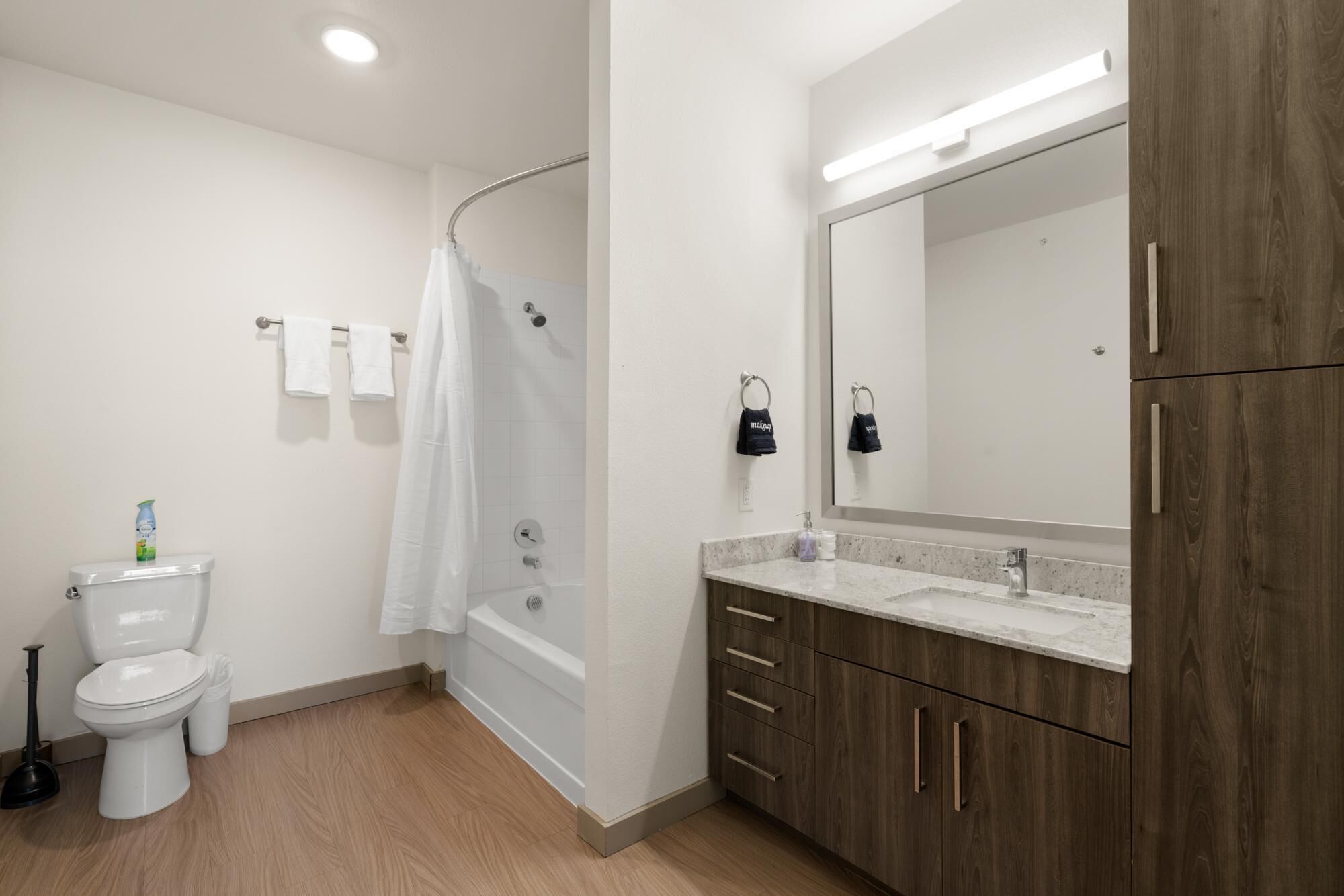 A modern bathroom with a toilet, shower, and vanity.