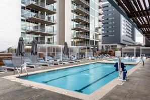 A modern hotel pool area with multiple pools, lounge chairs, and umbrellas. - Austin Upscale 1BD 1BA 2nd Street District Apartment (Austin)
