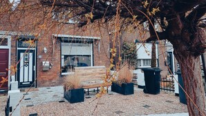 Un patio con un banco, plantas en macetas y un edificio de fachada de ladrillo.