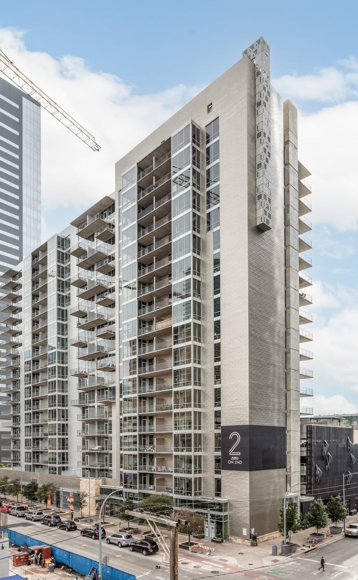 Un immeuble moderne à plusieurs étages, doté de nombreux balcons et de grandes fenêtres.